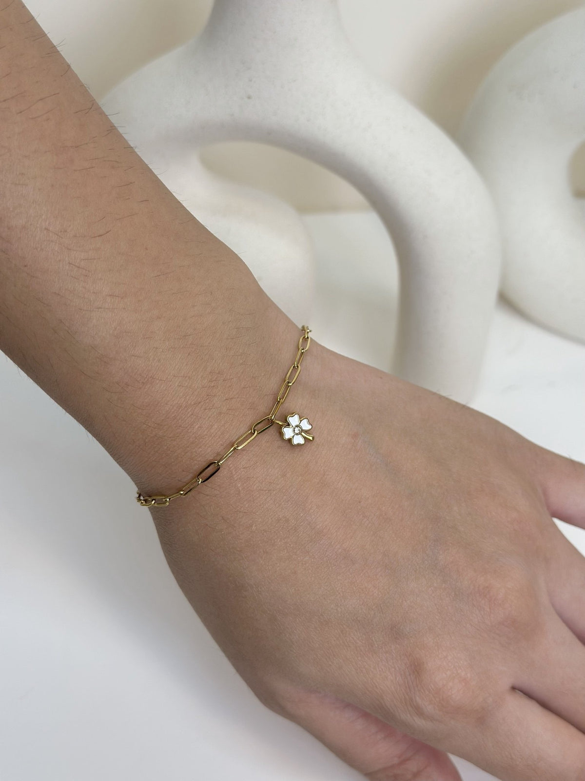 Paired Celandine Bracelet in gold-tone, side view on the wrist with a paperclip chain and flower charm