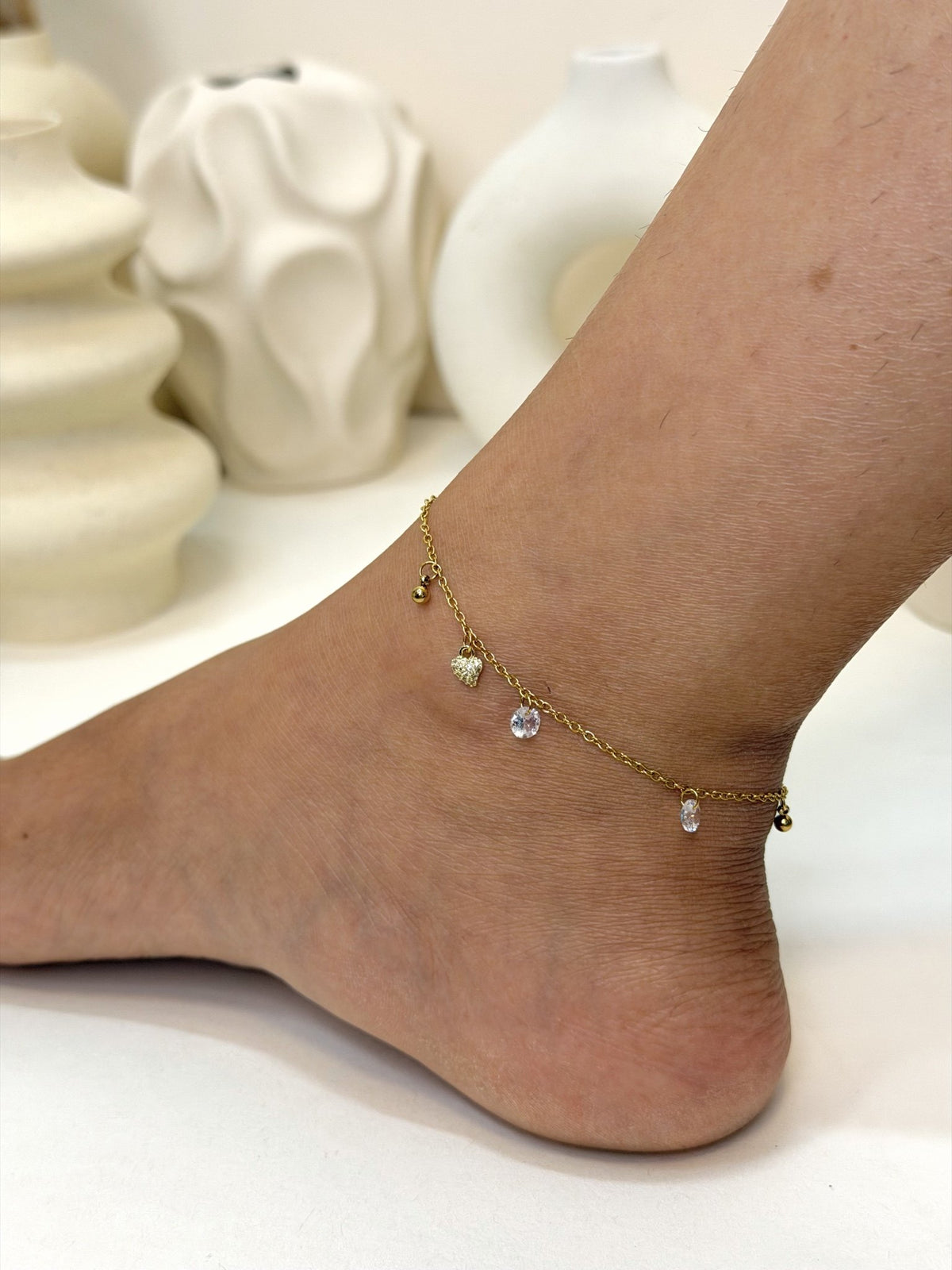 Paired Lunelle Anklet in gold-tone, side view on the ankle with small drop stones along the chain