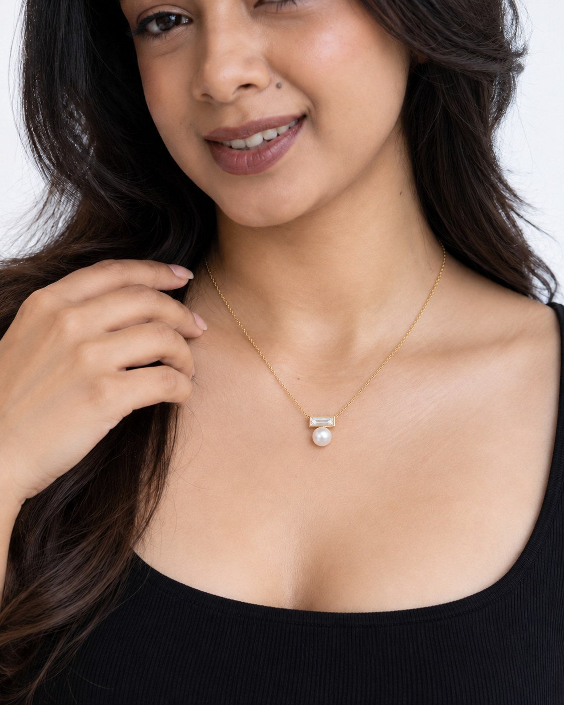 Paired Radiant Love Chain in gold-tone, worn close-up: clear baguette crystal bar with a centred white pearl drop