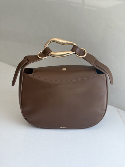 Paired Arden Soft Bag in coffee brown, with a soft rounded shape and a sculptural gold-tone ring handle, shown from the front