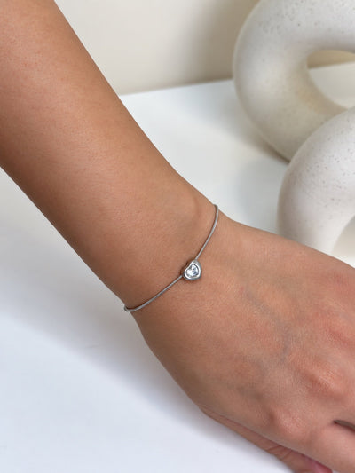 Paired Ariovelle Bracelet in silver-tone, close view on the wrist with a heart-shaped clear stone at the centre