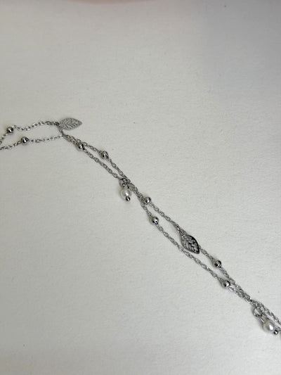 Paired Aurevia Anklet in silver-tone, laid flat showing layered beaded chains with leaf charms
