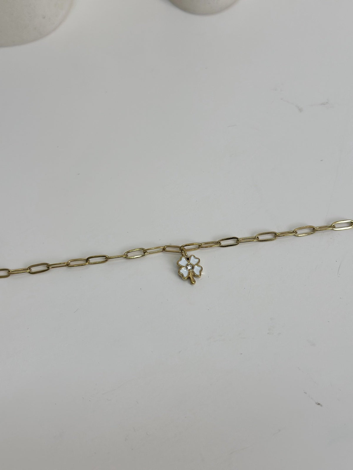 Paired Celandine Bracelet in gold-tone, laid flat showing the paperclip chain and white flower charm