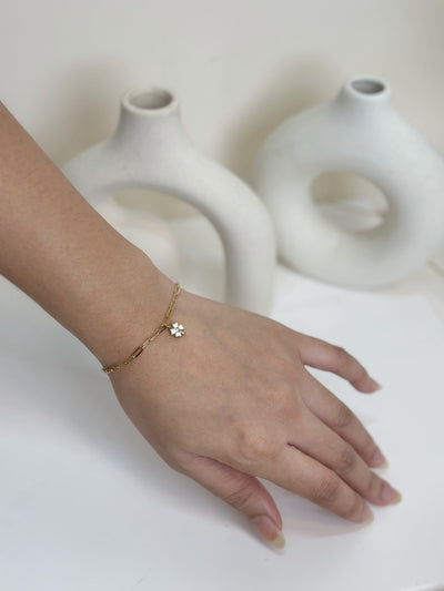 Paired Celandine Bracelet in gold-tone, worn on the hand with a paperclip chain and a white flower charm