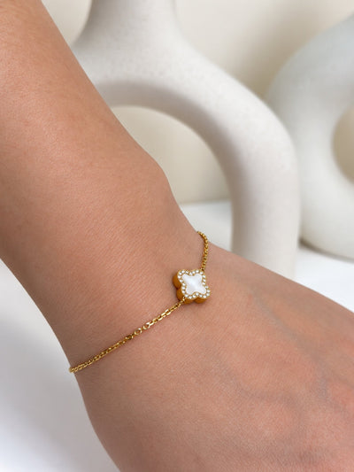 Paired Clover Étoile Bracelet in gold-tone, close view on the wrist showing the white clover charm with sparkling edge