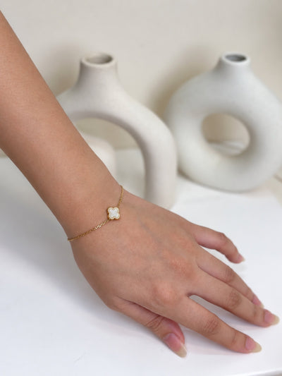 Paired Clover Étoile Bracelet in gold-tone, worn on the hand with a fine chain and a single white clover charm