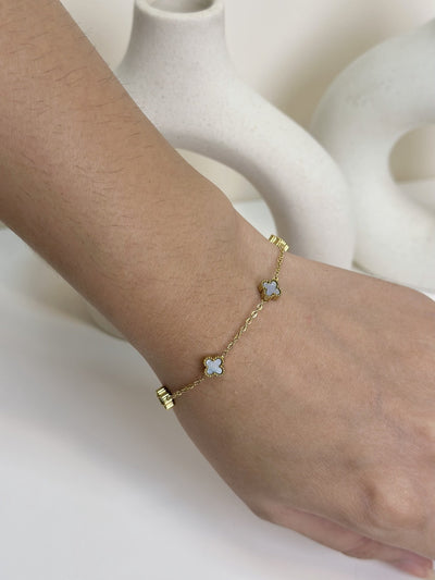 Paired Clover Petite Bracelet in gold-tone, close view on the wrist with pale clover-shaped motifs on a fine chain