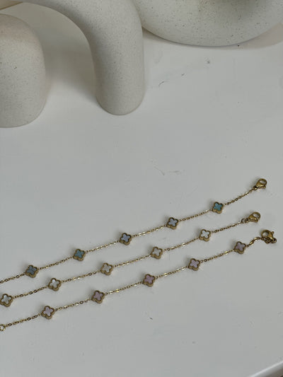 Paired Clover Petite Bracelet in gold-tone, three bracelets laid flat with clasps and pastel clover motifs