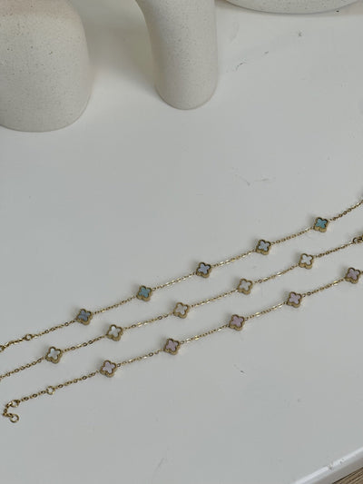 Paired Clover Petite Bracelet in gold-tone, three bracelets laid flat in white, blue and pink clover tones