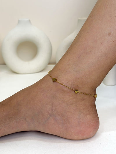 Paired Elara Anklet in gold-tone, side view on the ankle with a fine chain and small flower charms