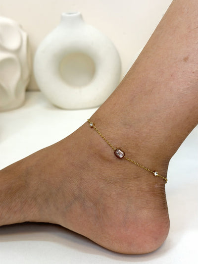 Paired Evania Anklet in gold-tone, worn on the ankle with a fine chain and soft pink and clear stones