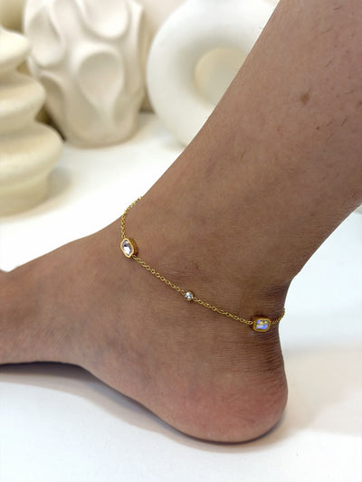 Paired Evania Anklet in gold-tone, close view on the ankle showing pink and clear stones on a fine chain