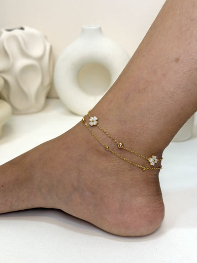 Paired Liora Anklet in gold-tone, side view on the ankle with layered chains and clover-shaped charms