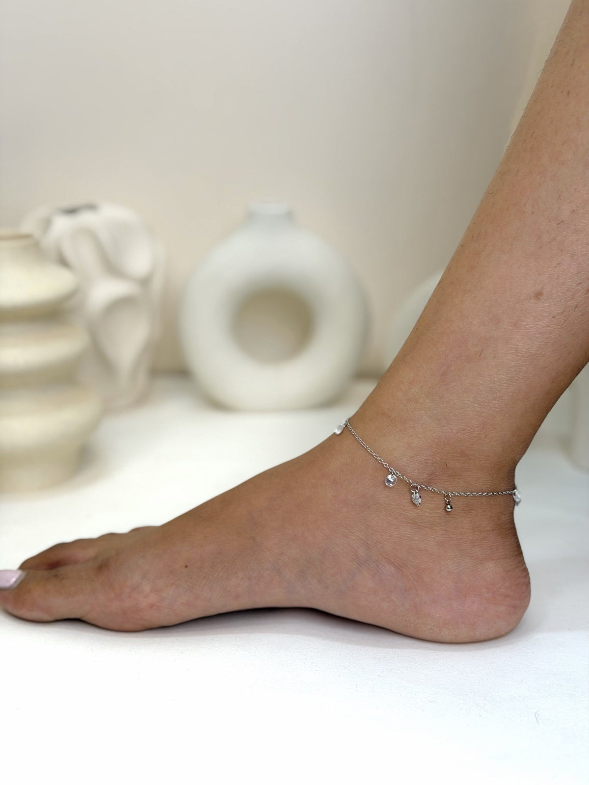 Paired Lunelle Anklet in silver-tone, worn on the foot and ankle with delicate clear drop stones