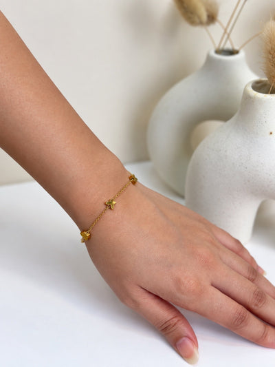 Paired Nerelia Bracelet in gold-tone, worn on the wrist with a fine chain and small butterfly charms
