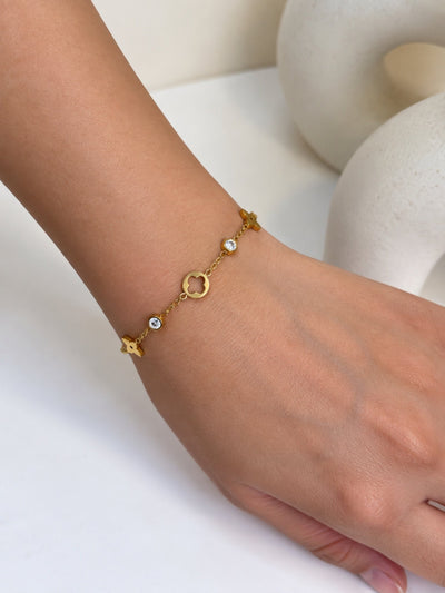 Paired Nolia Bracelet in gold-tone, close view on the wrist showing an open circle charm, star shape and clear stones