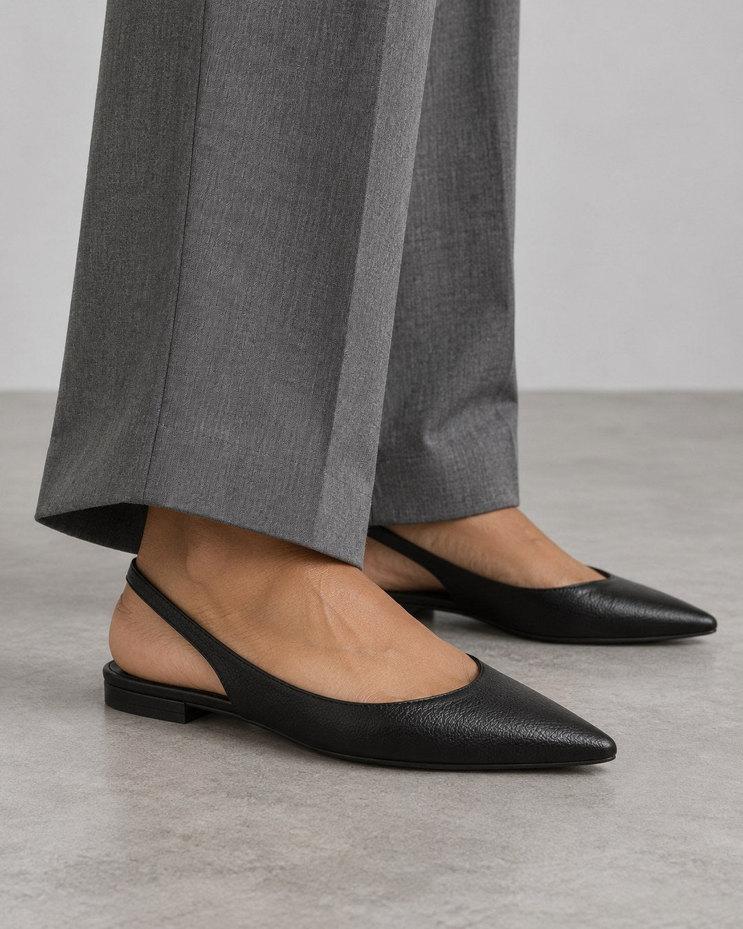 Paired Vintage Slingback: black pointed slingback flats worn with grey tailored trousers, for the office edit