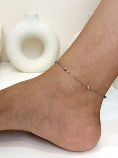 Paired Solène Anklet in silver-tone, worn on the ankle with a fine chain and small ball beads