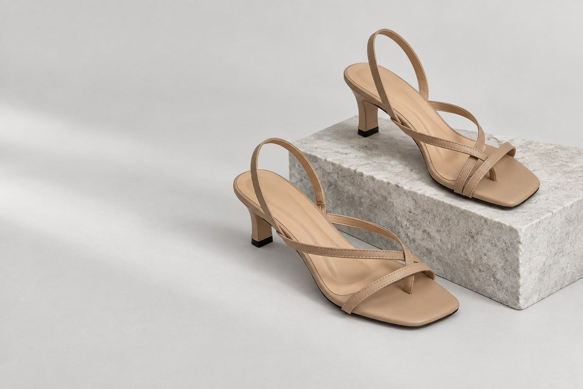 Paired nude strappy heels on a stone plinth