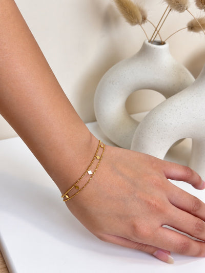 Paired Valleria Bracelet in gold-tone, worn on the wrist as a double beaded chain with small diamond-shaped charms