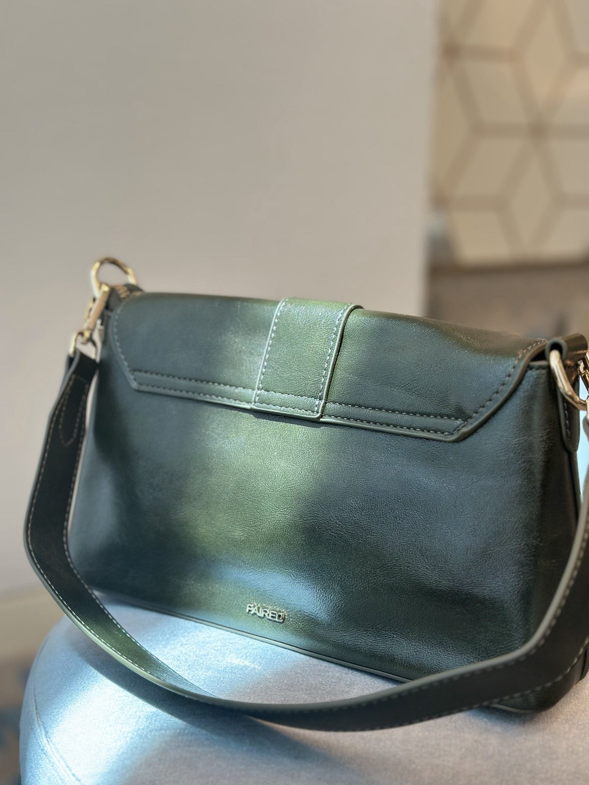 Paired Valora Buckle Sling Bag in deep green, seen from the back with a short strap and the Paired logo at the base